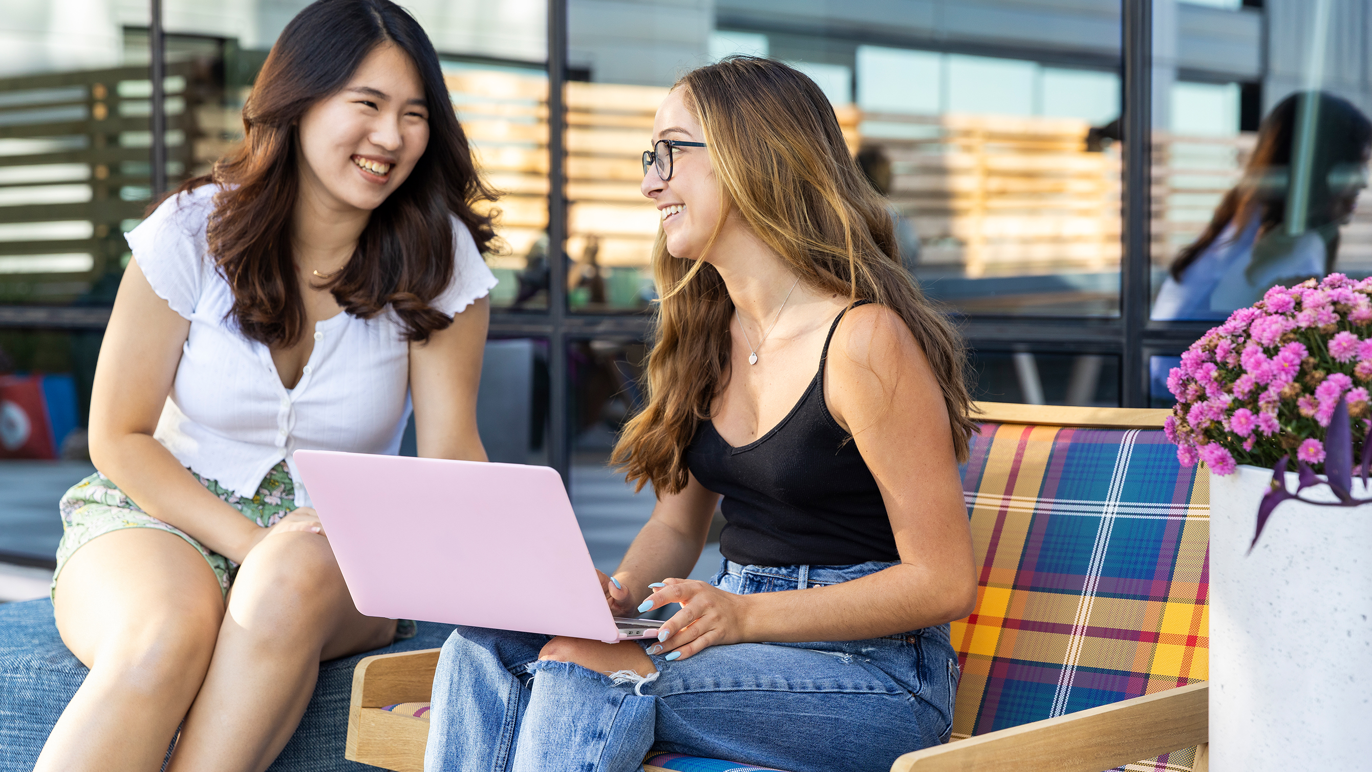 Two friends using a laptop